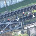 Pessoas andando nos trilhos de trem das Linhas 11, 12 e 13 da CPTM