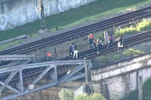 Pessoas andando nos trilhos de trem das Linhas 11, 12 e 13 da CPTM