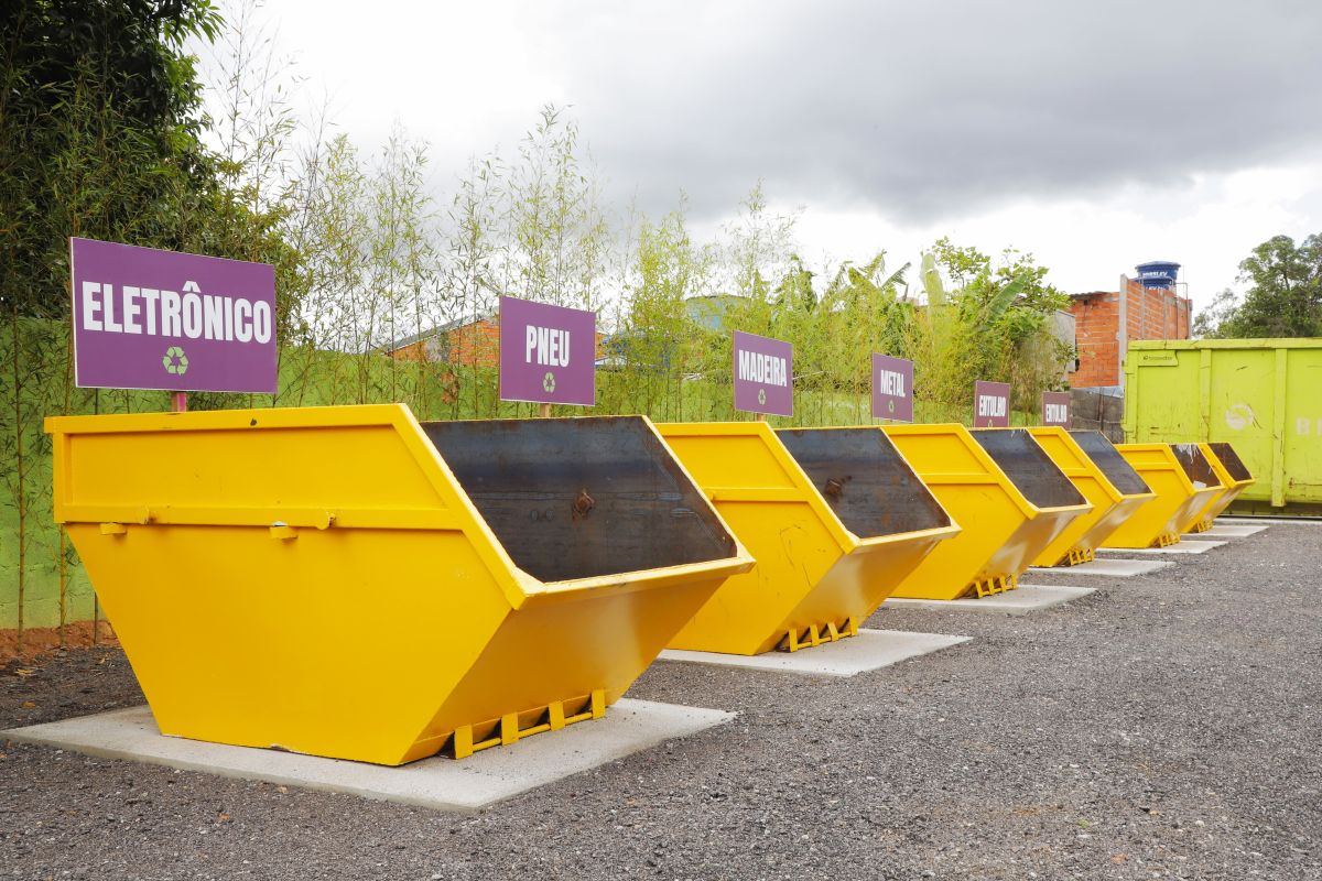 Caçambas amarelas alinhadas em ecoponto para descarte de resíduos separados como eletrônicos, pneus, madeira e metal em Osasco e Barueri.